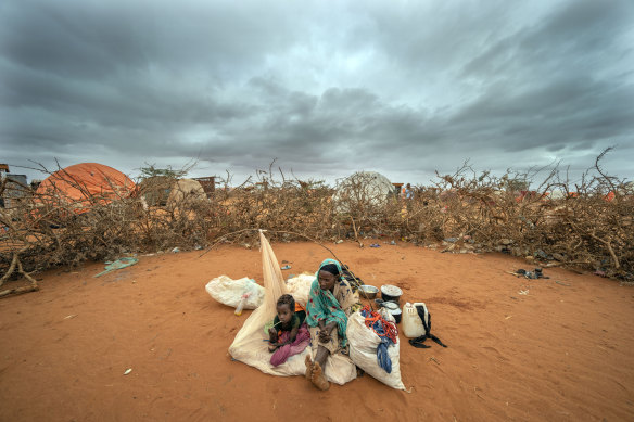 A woman and a child wait to be given a spot to settle at a camp for displaced people on the outskirts of Dollow, Somalia in September. 