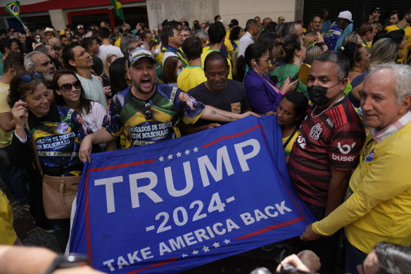 Supporters of Brazilian President Jair Bolsonaro show a Trump campaign flag during a re-election campaign rally for Bolsonaro in Juiz de Fora on Tuesday.