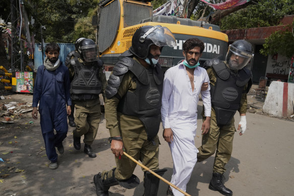 Police detain supporters of former prime minister Imran Khan during a search operation in the Khans’ residence, in Lahore, Pakistan, on Saturday.