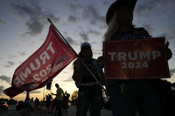 The sun sets as two women show their support for former president Donald Trump near his Mar-a-Lago estate in Palm Beach, Florida. 