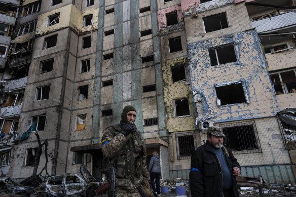 A soldier walks next to a destroyed building after a bombing in Kyiv’s Satoya neighbourhood.