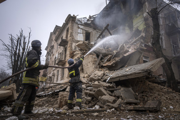 Ukrainian State Emergency Service firefighters work to extinguish a fire at the building which was destroyed by a Russian attack in Kryvyi Rih.