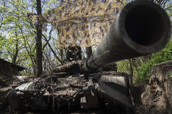 Ukrainian serviceman install a machine gun on the tank during the repair works after fighting against Russian forces in Donetsk region.
