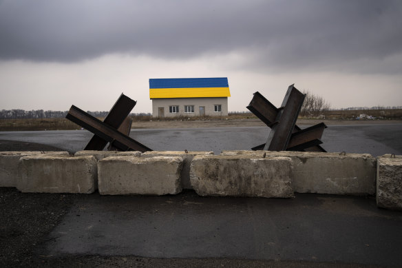 Anti-tank barriers are displayed near a house painted with the colors of the Ukraine flag near Malaya Alexandrovka village.