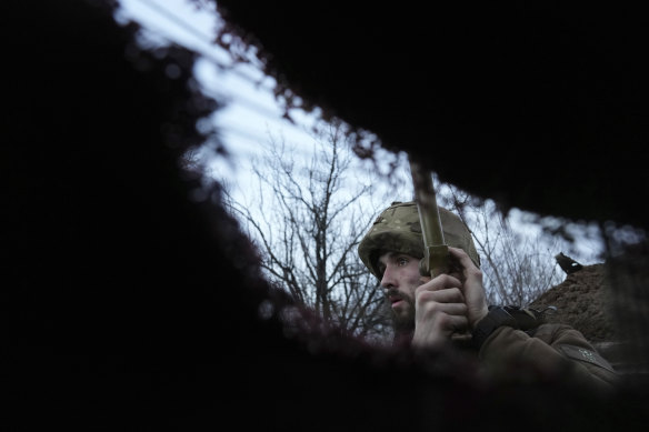 A Ukrainian service member listens to artillery shots standing in a trench on a position at the line of separation between Ukraine-held territory and rebel-held territory near Zolote, Ukraine.