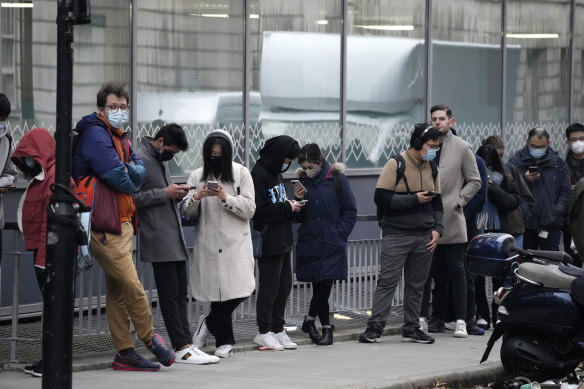 People line up to get a COVID-19 booster shot at University College London this month.