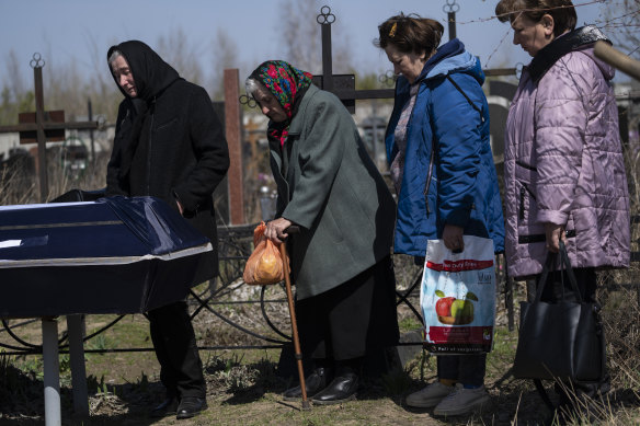 Ol’ga Kosyanchuk, 63, left, stands next to the coffin of her husband Anatoliy Kosyanchuk, 56, who was captured by Russian soldiers on March 29, and found dead with heavy head injuries in Bucha.