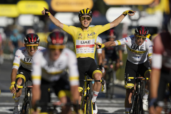 Slovenia’s Tadej Pogacar, wearing the yellow jersey, celebrates as he crosses the finish line to win 2021 Tour de France.