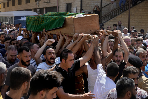 Mourners chant slogans as they carry the coffin of Palestinian Abdul-Al Omar Abdul-Al, 24, who was on a boat carrying migrants from Lebanon that sank in Syrian waters, during his funeral processions, in the Palestinian refugee camp of Nahr el-Bared near the northern city of Tripoli.