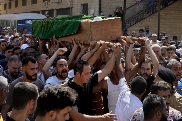 Mourners chant slogans as they carry the coffin of Palestinian Abdul Al Omar Abdul Al, 24, near the northern city of Tripoli.