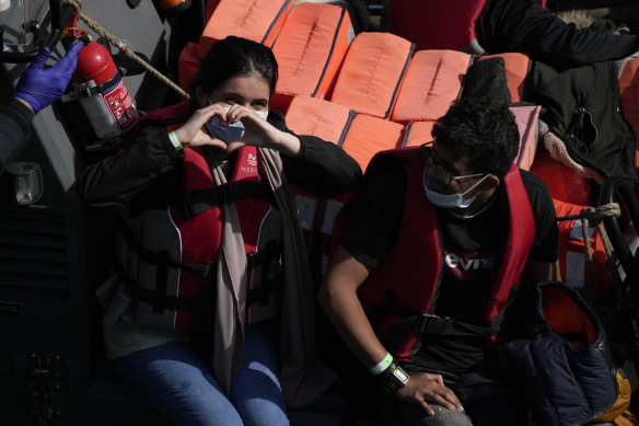 A woman thought to be a migrant who undertook the crossing from France in a small boat waits on a transfer boat in Dover, Britain.