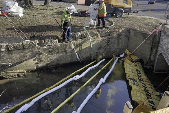 Booms are placed in a stream that flows through the centre of East Palestine, Ohio, as the clean-up continues.