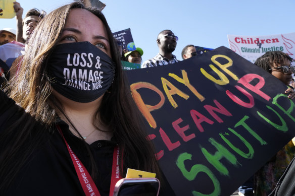 A demonstrator holds a sign that reads “pay up clean up shut up” during a protest at the COP27 U.N. Climate Summit.