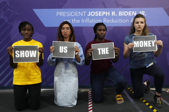 From left: Vanessa Nakate, of Uganda, Mitzi Jonelle Tan, of the Philippines, Precious Kalombwana, of Zambia, and Dominika Lasota, of Poland, hold signs that read “show us the money” at the US Centre at the COP27 UN Climate Summit.
