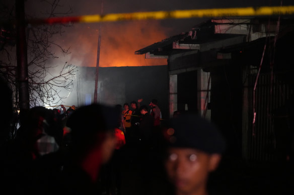 Rescuers inspect a neighborhood affected by the large fire in Jakarta, Indonesia. 
