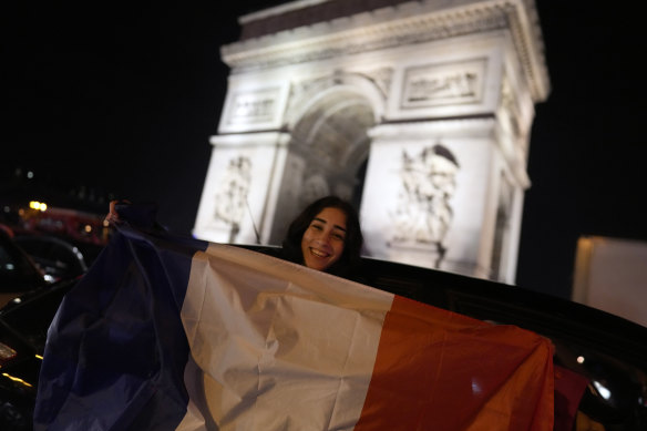 Supporters of France react next to the Arc de Triomphe and the Champs Elysees avenue at the end of the World Cup semifinal soccer match between France and Morocco on Wednesday, December 14.
