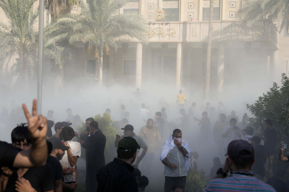 Iraqi security forces fire tear gas on followers of Shiite cleric Muqtada al-Sadr protesting inside the government palace grounds, in Baghdad, Iraq. 