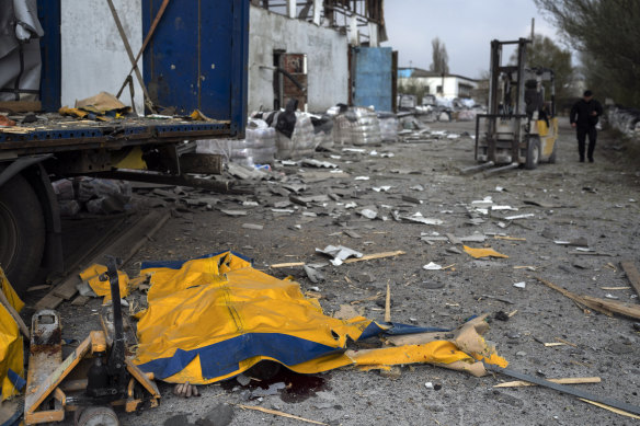 The body of a man is covered by a tarp from a damaged truck following a Russian bombing of a factory in Kramatorsk.