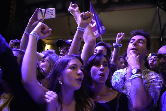 Supporters of hard-left leader Jean-Luc Melenchon react inside his election night headquarters on Sunday.