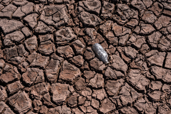A bottle sits in dried mud on the shore of the Beacons Reservoir as it lies low during the current heat wave in Merthyr Tydfil, Wales.