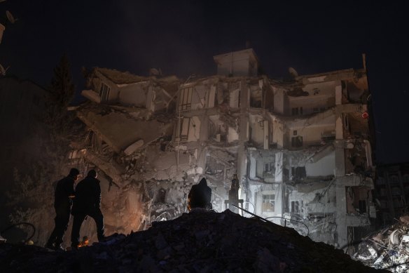 Rescuers and people search in a destroyed building in Kahramanmaras, Turkey. 