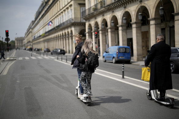 Turistler Paris'te Rivoli caddesinde scooter'a biniyor, 