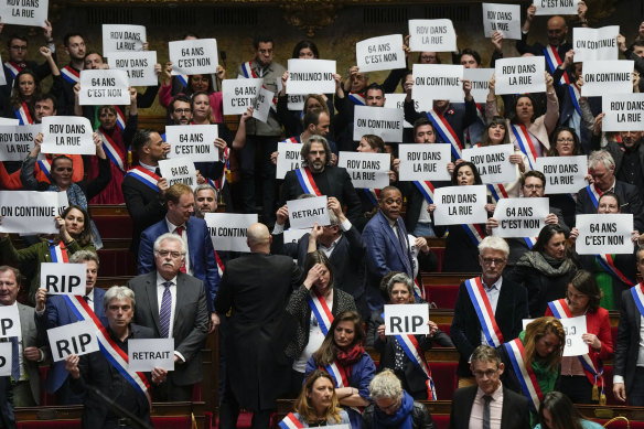 Far-left MPs react as they hold papers reading: “64 years. It is no”, “appointment in the street”, “we are continuing”, at the National Assembly in Paris.