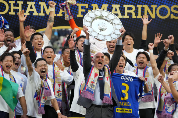 Kevin Muscat lifts the J.League trophy with Yokohama F. Marinos last weekend.