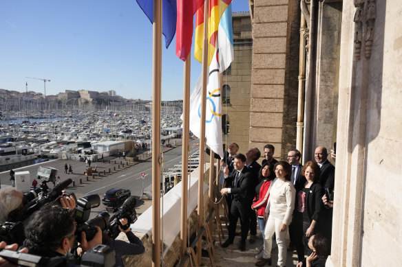 Marsilya Belediye Başkanı Benoit Payan (solda), Şubat ayında Fransa'nın güneyindeki Marsilya Belediye Binasında Paris 2024 Olimpiyatları Başkanı Tony Estanguet (ortada) ile birlikte Olimpiyat bayrağını dalgalandırıyor.