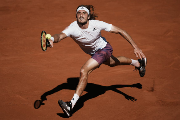 Stefanos Tsitsipas reaches for the ball against Novak Djokovic.