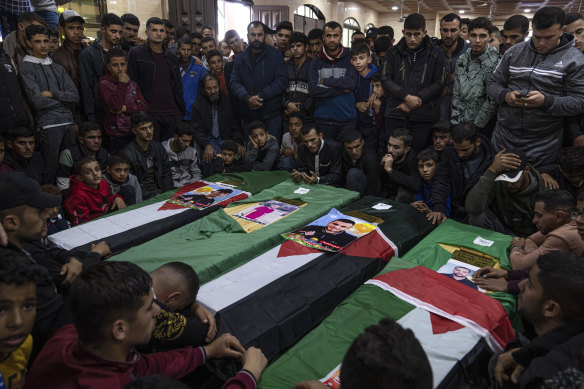 Mourners gather around the coffins of four Palestinians who died off the Tunisian coast, during their funeral at a mosque in Rafah in the southern Gaza Strip.
