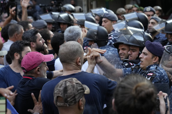 Lebanese riot police officers push back anti-bank protesters who arrived to support Bassam al-Sheikh Hussein.