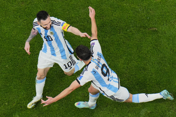 Lionel Messi and Julian Alvarez celebrate a goal.