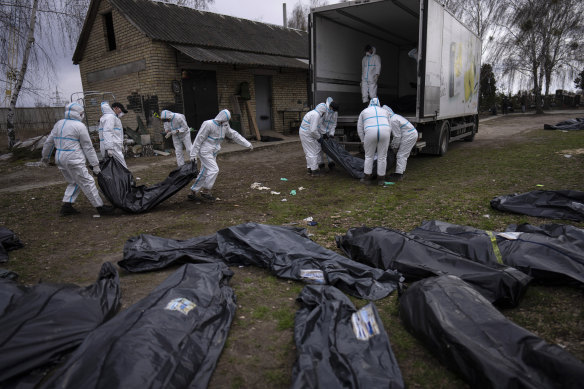 Volunteers load bodies of civilians killed in Bucha onto a truck to be taken to a morgue for investigation.