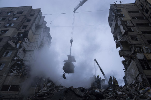 Rescue workers clear the rubble from an apartment building that was destroyed in a Russian rocket attack at a residential neighbourhood in the city of Dnipro, 