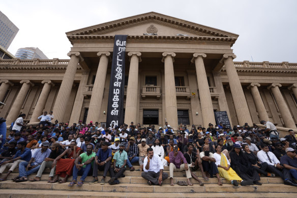 Sri Lankans attend a peaceful sit down protest demanding the ouster of Prime Minister and acting president Ranil Wickremesinghe on Wednesday.