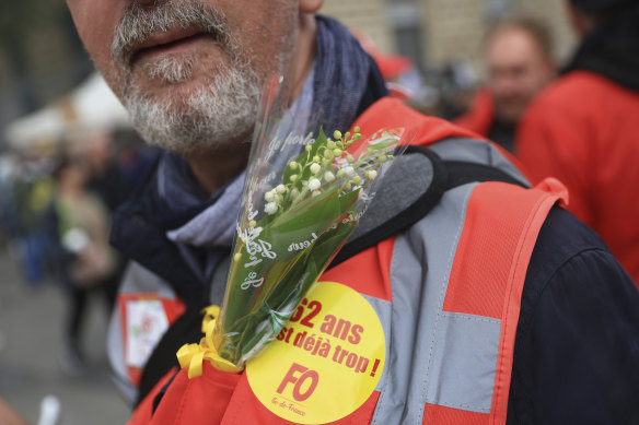 An unionist displays the traditional Lily of the Valley flower (muguet) on his jacket during a demonstration in Paris on May 1. The flower symbolises good luck, happiness, and the arrival of spring.