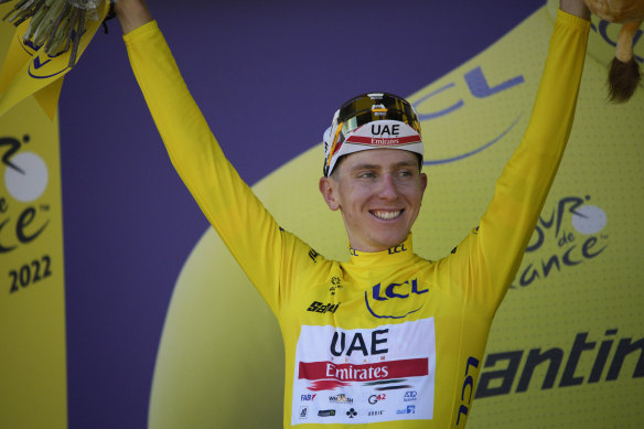 Slovenia’s Tadej Pogacar, wearing the overall leader’s yellow jersey, celebrates on the podium.