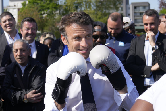 French President Emmanuel Macron wears boxing gloves while campaigning in 2022.