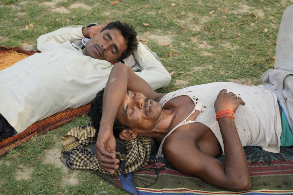 People sleep in the shade of a tree on a hot summer afternoon in Lucknow in the central Indian state of Uttar Pradesh. 