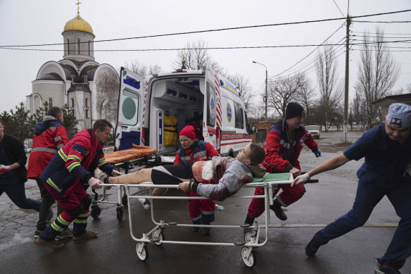 Ukrainian paramedics move an injured man wounded by Russian shelling in a residential area to a maternity hospital in Mariupol.
