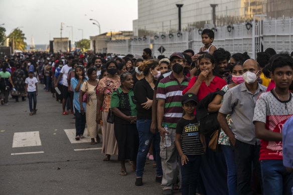 People wait in queue to enter the official residence of president Gotabaya Rajapaksa three days after it was stormed by anti-government protesters in Colombo.