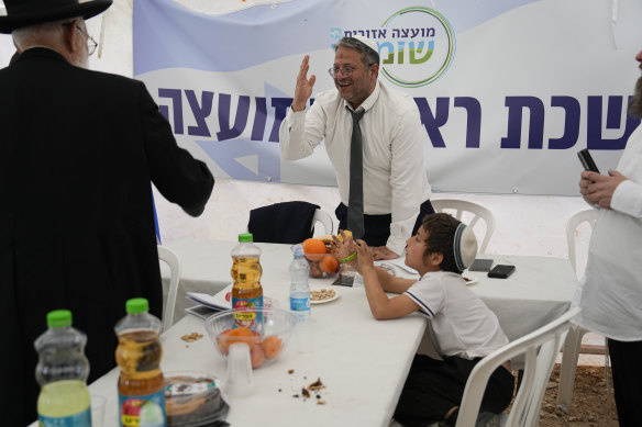 Israeli National Security Minister Itamar Ben-Gvir greets people at the outpost of Eviatar in the West Bank, where visits were previously prohibited.