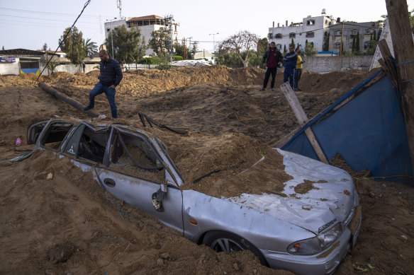 Palestinians inspect damage from overnight Israeli airstrikes in Gaza City on Friday.