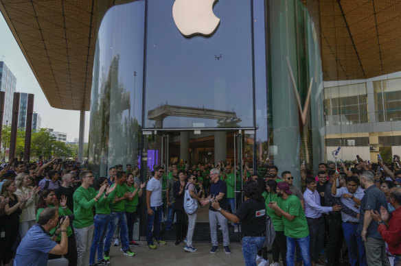 Apple chief Tim Cook (centre) welcomes a visitor during the opening of Apple’s flagship store in Mumbai.