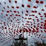 A man hangs up flags in Hanoi in preparation for Vietnam’s national day under a cloudy sky caused by Typhoon Kajiki on Monday.
