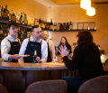 Two busy bartenders work in tandem behind the bar.