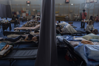 People who fled the war in Ukraine rest inside an indoor sports stadium of a high school in Poland.
