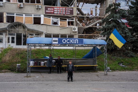 People wait for a bus to leave Kupiansk on Thursday.