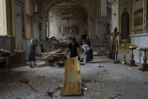 People clean up inside the Transfiguration Cathedral after it was shelled by Russia.